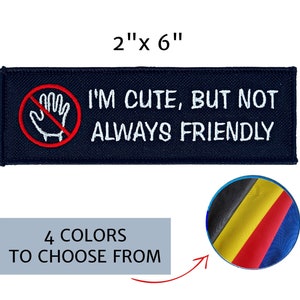 May include: A navy blue embroidered patch, measuring 2 x 6 inches, with the text "I'M CUTE, BUT NOT ALWAYS FRIENDLY" in white. It features a red circle with a hand symbol crossed out. The image also shows a color palette with four color options.