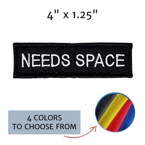 May include: A rectangular black embroidered patch with the white text NEEDS SPACE, measuring 4 inches by 1.25 inches. A circular graphic shows four fabric color options including black, yellow, red, and blue, with text 4 COLORS TO CHOOSE FROM.
