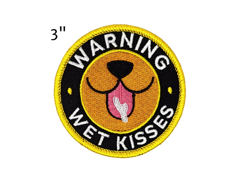 Puede incluir: Parche bordado, 7,6 cm de di&aacute;metro, con un dise&ntilde;o de cara de perro. El parche presenta una cara de perro amarilla con una lengua rosa y las palabras "WARNING WET KISSES" en letras blancas sobre un fondo negro, rodeado por un borde amarillo.