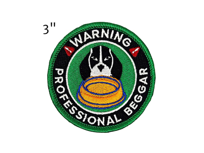 May include: Embroidered patch, 3 inches in diameter, featuring a black and white dog with a bowl. The patch has a green border and the words "WARNING PROFESSIONAL BEGGAR" in white text. Red warning symbols are also present.