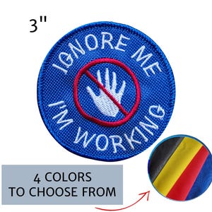 May include: A round, blue embroidered patch with the text "IGNORE ME I'M WORKING". The patch features a white hand inside a red circle with a red line through it. The patch is 3 inches in diameter. Additional color options are shown.