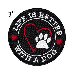 May include: A round, black patch with the text "LIFE IS BETTER WITH A DOG" in white. A red heart and a white paw print are in the center. The patch is 3 inches in diameter.