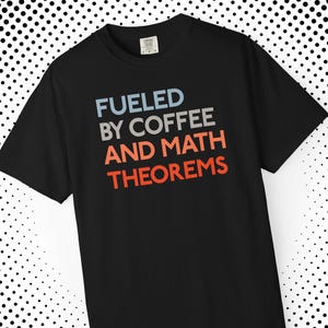 Puede incluir: Camiseta negra con el texto "FUELED BY COFFEE AND MATH THEOREMS" en azul, gris y naranja. La camiseta es de cuello redondo y parece estar hecha de un material suave. Una prenda de vestir informal.