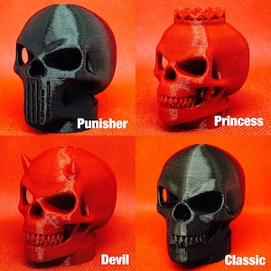 May include: Four 3D printed skull designs: Punisher, Princess, Devil, and Classic. The Punisher and Classic skulls are black, while the Princess and Devil skulls are red.
