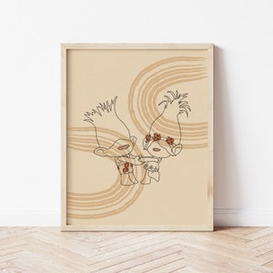 Puede incluir: Una impresión enmarcada con un dibujo lineal minimalista de dos personajes de Trolls. La obra de arte está en tonos marrones y beige, con un diseño caprichoso. La impresión está en un marco de madera de color claro, adecuado para una habitación infantil o guardería.