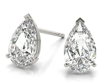 May include: A pair of pear-shaped diamond stud earrings in a silver setting.