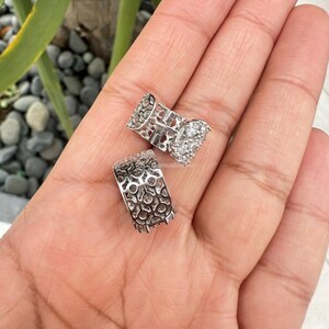Puede incluir: Un par de pendientes de aro de plata con un delicado dise&ntilde;o de filigrana y piedras de circonita c&uacute;bica transparentes.