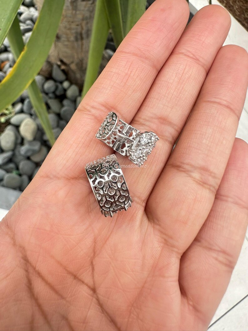 Puede incluir: Un par de pendientes de aro de plata con un delicado dise&ntilde;o de filigrana y piedras de circonita c&uacute;bica transparentes.