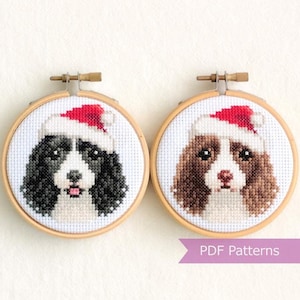 Op de afbeelding: Twee kruissteekpatronen van honden die kerstmanmutsen dragen. De patronen zijn in borduurringen en klaar om te borduren.