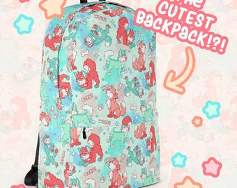 May include: A backpack with a repeating pattern of cartoon dogs in red and teal on a light blue background. The backpack has black straps and a top handle. Text on the backpack says "The Cutest Backpack?!"