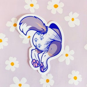 May include: A cartoon sticker of a grey and white dog wearing a blue nappy with paw prints. The dog is facing away from the viewer and has its tail curled up.