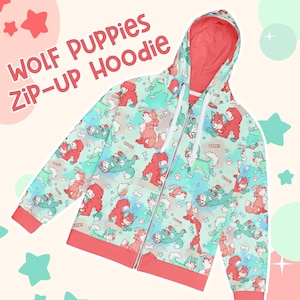 Peut inclure: Un sweat à capuche zippé avec un motif répété de chiots loups de dessin animé rouges et verts sur un fond bleu clair. Le sweat à capuche a un intérieur et une bordure de couleur corail, avec les mots "WOLF PUPPIES ZIP-UP HOODIE" en texte rouge.