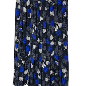 May include: A pleated skirt with a black background and a floral pattern. The flowers are in shades of blue, white, and gray. The skirt is hanging on a white hanger.
