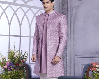 May include: A lavender patterned long-sleeved jacket with a mandarin collar and a white button-up shirt underneath. The jacket has a long, flowing design and is paired with white pants and black shoes.