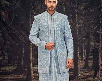 Könnte beinhalten: Eine hellblaue Jacke mit langen Ärmeln und einem weißen und hellblauen Muster. Die Jacke hat einen Stehkragen und einen Knopfverschluss. Das Model trägt eine weiße Hose und weiße Schuhe.