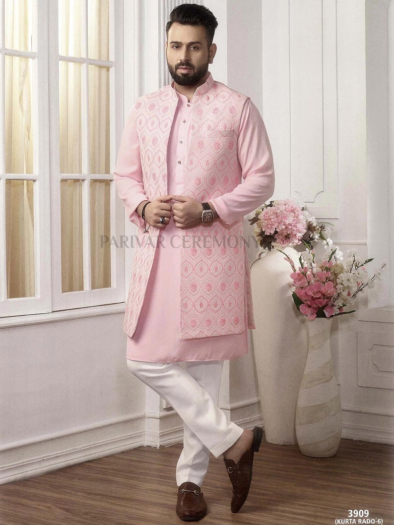 Puede incluir: Un traje kurta rosa claro con un chaleco bordado a juego y pantalones blancos. El conjunto presenta un cuello mandar&iacute;n y se combina con mocasines de cuero marr&oacute;n. El texto "PARIVAR CEREMONY" es visible.