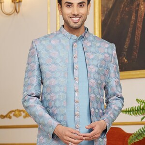 May include: A light blue patterned jacket with a matching light blue shirt. The jacket has a mandarin collar and a button closure. The shirt has a button-up closure.