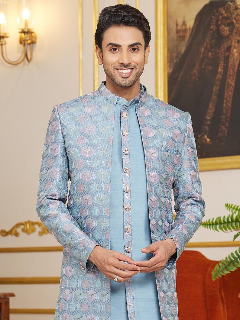 May include: A light blue patterned jacket with a matching light blue shirt. The jacket has a mandarin collar and a button closure. The shirt has a button-up closure.