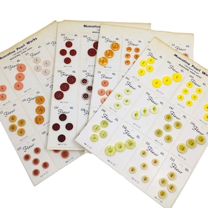 May include: A collection of vintage button cards from Muscatine Pearl Works. The cards display various sizes and colors of buttons, including shades of red, yellow, and cream. The word "Fleur" is printed on each card.