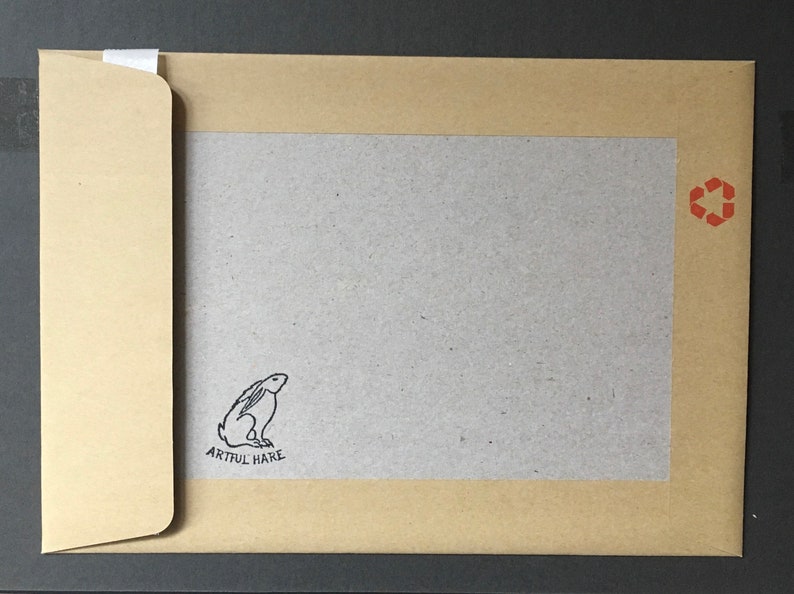 May include: A brown paper envelope with a white flap. The envelope has a gray inner lining with a black and white illustration of a rabbit and the text "Artful Hare". The envelope has a red recycling symbol in the upper right corner.