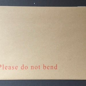 May include: A brown paper envelope with the text "Please do not bend" printed in red.