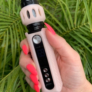 Puede incluir: Un cigarrillo electrónico rosa y negro con una pantalla digital que muestra "69". El dispositivo tiene una superficie texturizada y un botón negro.