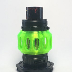 May include: A vaping device with a black base and a bright green, cage-like midsection. The top features a black cap with a marbled, red and brown mouthpiece. The device is designed for vaping.
