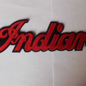 May include: Embroidered patch featuring the word "Indian" in red script lettering with a black border. The patch is likely for a motorcycle or vintage vehicle enthusiast.