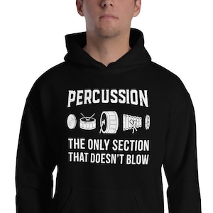 Può includere: Felpa con cappuccio nera con testo bianco che recita "PERCUSSION THE ONLY SECTION THAT DOESN'T BLOW" e una grafica di tamburi, piatti e un tamburello.