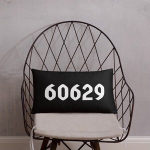 Könnte beinhalten: Schwarzes Kissen mit weißem Text "60629" auf schwarzem Hintergrund. Das Kissen liegt auf einem schwarzen Metallstuhl mit weißem Kissen.