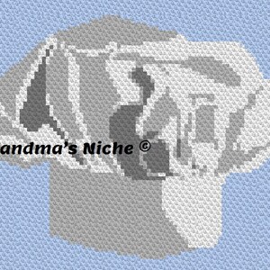 May include: A gray and white crochet pattern of a dog's head. The pattern is made with small squares and is a simple design. The text "Grandma's Niche®" is in the lower left corner of the image.