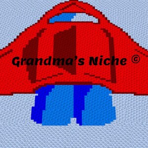 Könnte beinhalten: Eine Häkeldecke mit einem verpixelten roten Raketendesign auf hellblauem Hintergrund. Die Rakete hat ein dunkelrotes Zentrum, ein blaues Fenster und blaue Abgasflammen am unteren Rand. Der Text Grandma's Niche ist in Schwarz aufgedruckt.