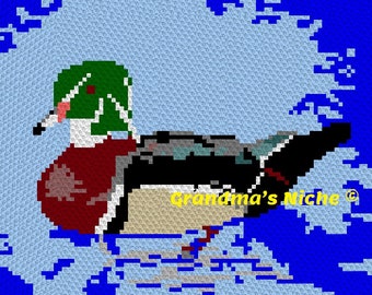 May include: A green-headed wood duck with a red breast and black and white wings is swimming in blue water. The duck is in a pixelated style, and the image has the text "Grandma's Niche" in yellow.