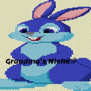May include: A blue crochet bunny with pink ears and a white smile. The bunny is sitting on a white background with the text "Grandma's Niche" in the lower center of the image.