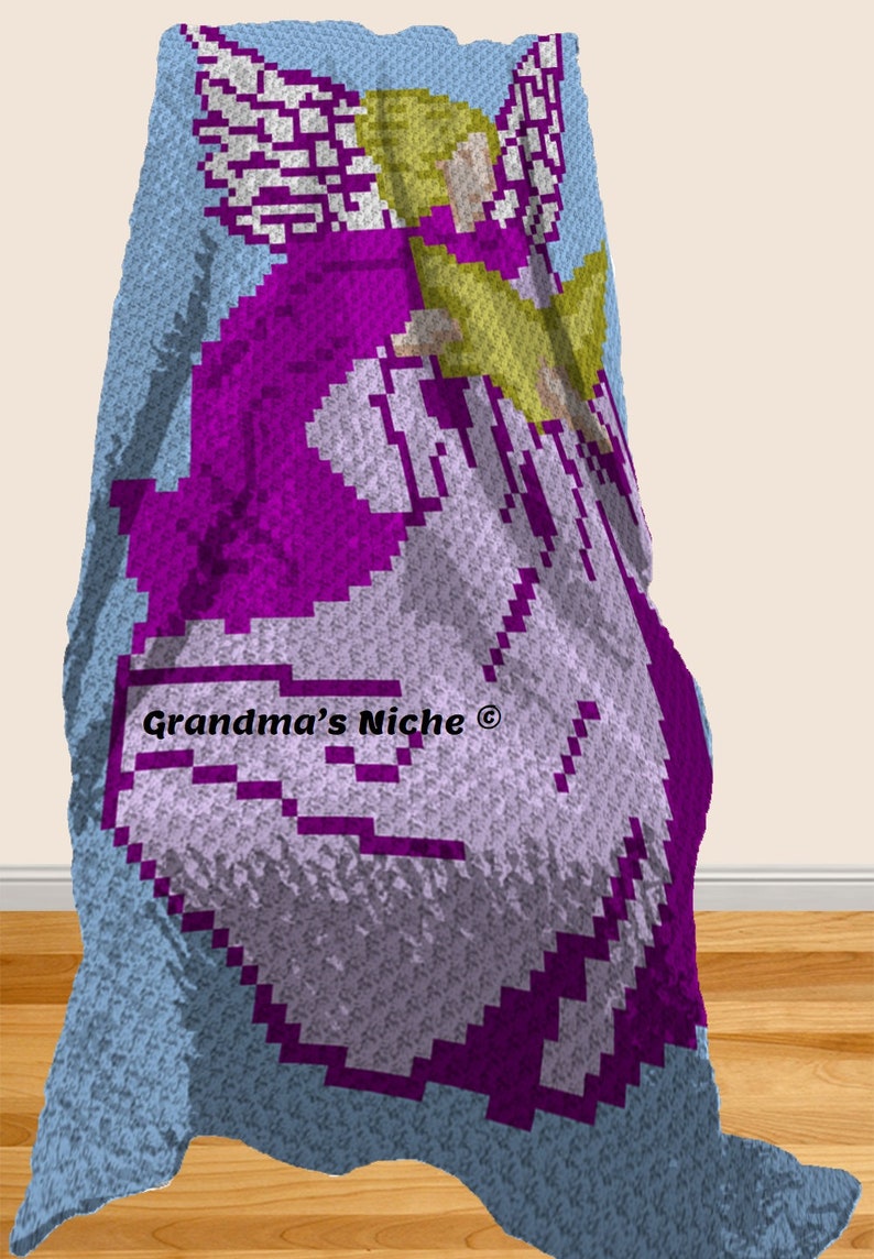 May include: A crocheted baby blanket with a purple angel design. The blanket is light blue with a white border. The angel has a yellow halo and white wings. The text "Grandma's Niche&reg;" is in the lower left corner.