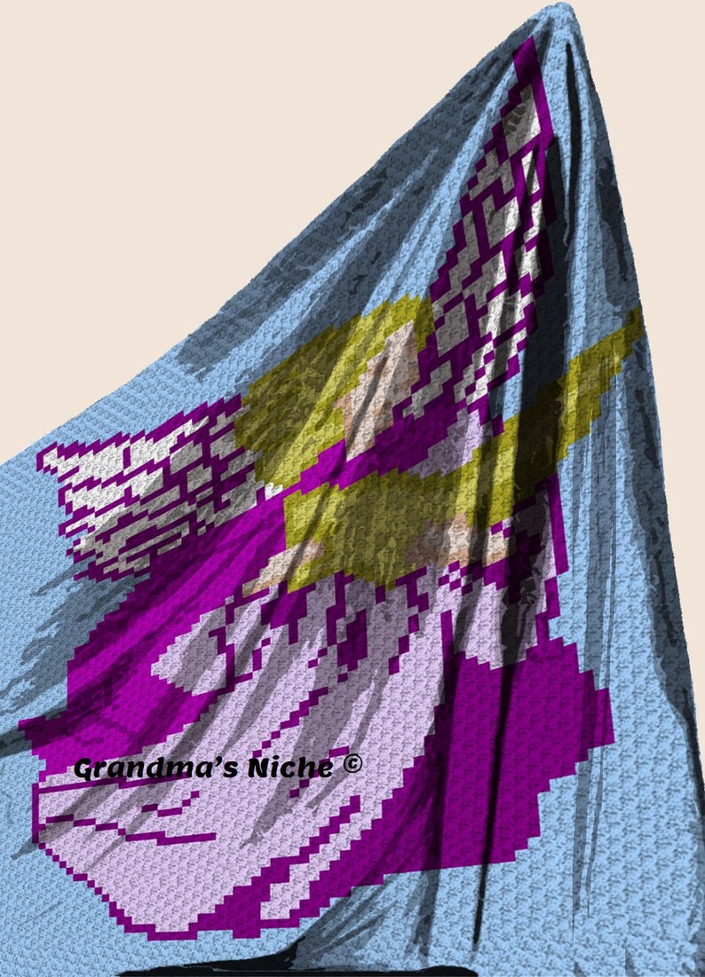 May include: A crochet blanket featuring a purple angel with yellow hair and wings. The blanket is light blue with a white border. The text "Grandma's Niche&reg;" is in the bottom left corner.