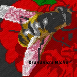 May include: A close-up of a crocheted bee on a red flower. The bee has black and yellow stripes and pink wings. The text "Grandma's Niche ©" is visible in the lower right corner of the image.