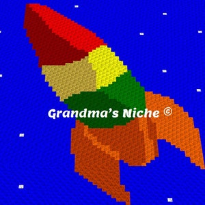 May include: A colorful rocket ship design on a blue background with white stars. The rocket is made of red, orange, yellow, green, and brown squares. The text "Grandma's Niche ©" is in the center of the image.