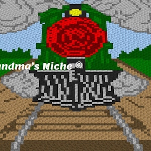 Puede incluir: Un patrón de crochet de una locomotora roja con follaje verde y una estrella amarilla en la parte superior. El tren está en una vía marrón con humo gris saliendo del motor. El texto "Grandma's Niche ©" es visible en la imagen.