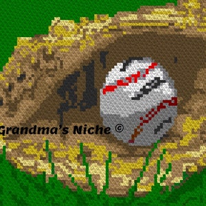 Op de afbeelding: Een bruine leren honkbalhandschoen met een witte honkbal erin. De handschoen ligt op een groene grasachtige achtergrond. De tekst "Grandma's Niche" is zichtbaar op de handschoen.