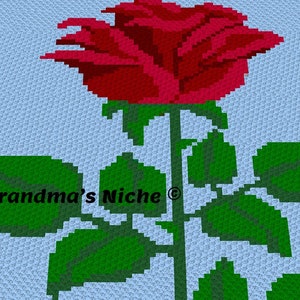 Peut inclure: Une rose rouge avec des feuilles vertes sur un fond bleu clair. Le texte "Grandma's Niche ©" est visible dans le coin inférieur gauche de l'image.