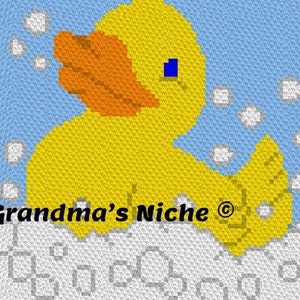 May include: A yellow rubber ducky with an orange beak and blue eyes is floating in a white foamy bath. The text "Grandma's Niche ©" is visible in the bottom left corner of the image.