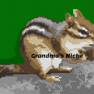 May include: A brown and white crocheted chipmunk sitting on a gray rock. The chipmunk is looking to the right and has its mouth open. The text "Grandma's Niche®" is visible in the image.