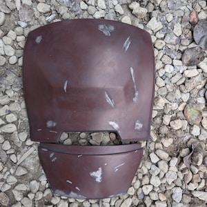 Op de afbeelding: Een tweedelig, bruin, plastic, kostuum-pantser borststuk met een verweerde afwerking. Het pantser is gemaakt om eruit te zien alsof het in de strijd is gedragen.