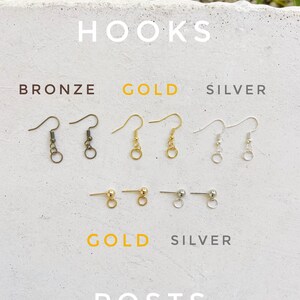 May include: A selection of earring hooks and posts in bronze, gold, and silver. The hooks are shown in three rows, with bronze on top, gold in the middle, and silver on the bottom. The posts are shown in two rows, with gold on top and silver on the bottom. The text "HOOKS" is at the top of the image, and the text "POSTS" is at the bottom.