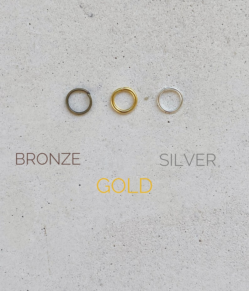 Puede incluir: Tres anillos de salto en bronce, oro y plata.