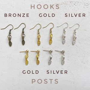 Image of earring hardware choices. The top left are bronze hooks. The top middle are gold hooks. The top right are silver hooks. The bottom left are gold ball posts. The bottom right are silver ball posts.
