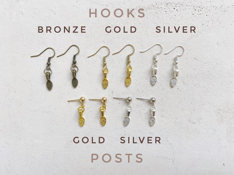 Image of earring hardware choices. The top left are bronze hooks. The top middle are gold hooks. The top right are silver hooks. The bottom left are gold ball posts. The bottom right are silver ball posts.