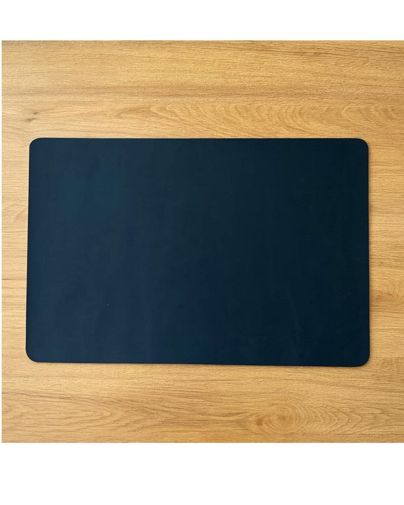 Muted navy leather desk blotter, full grain leather desk mat with rounded corners, centered on wood table