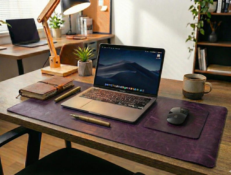 Plum purple full grain leather desk mat with vintage grain, laptop, mouse and desk lamp accent